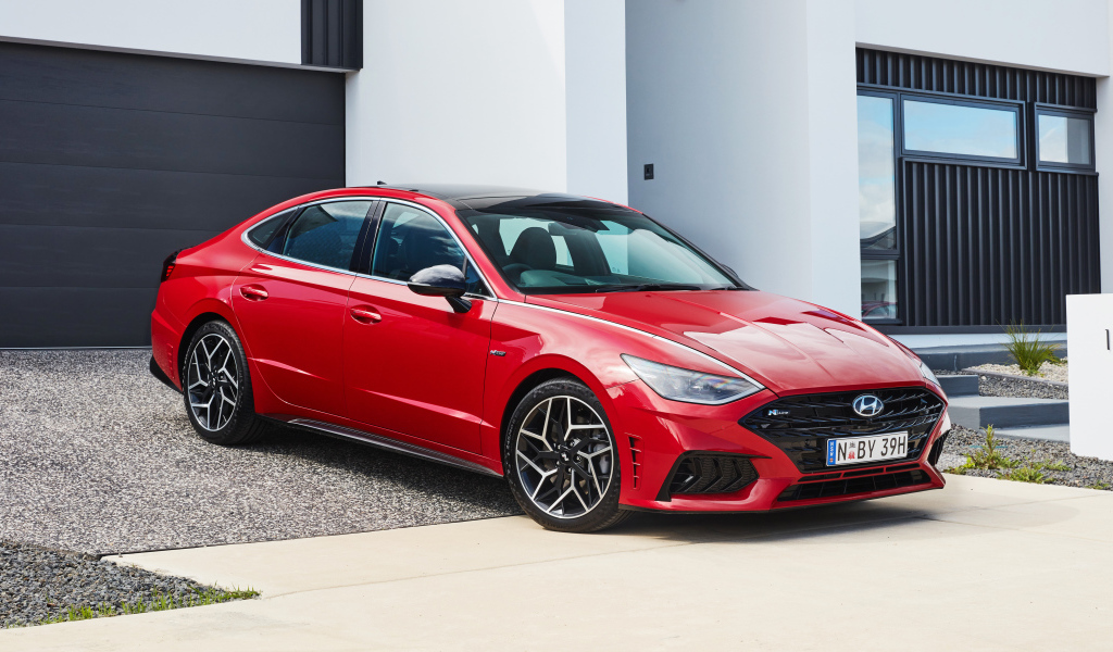 Красный автомобиль Hyundai Sonata N Line 2021 года у гаража