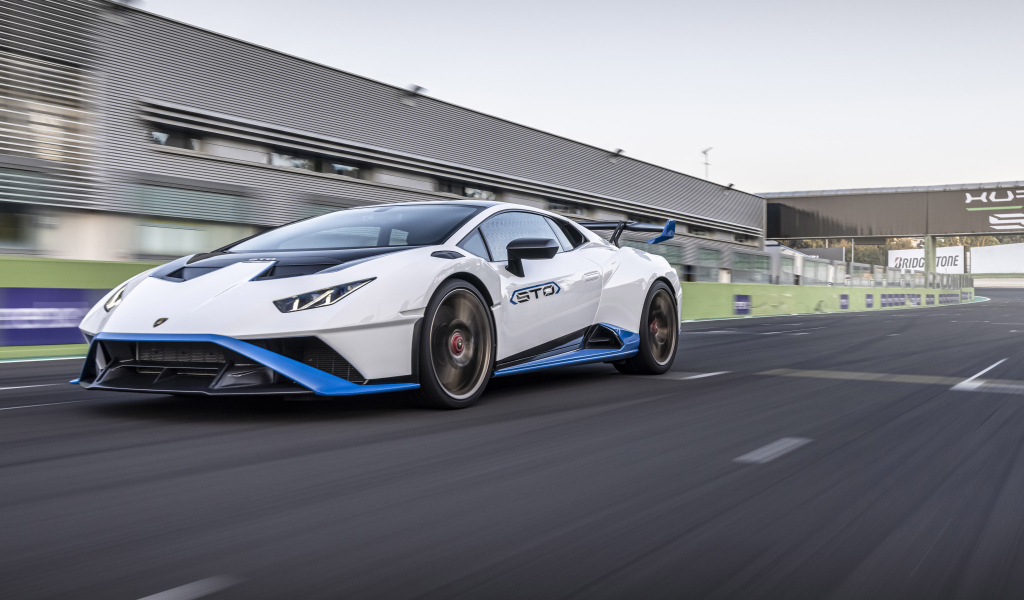 Белый автомобиль Lamborghini Huracán STO 2021 года на стадионе 