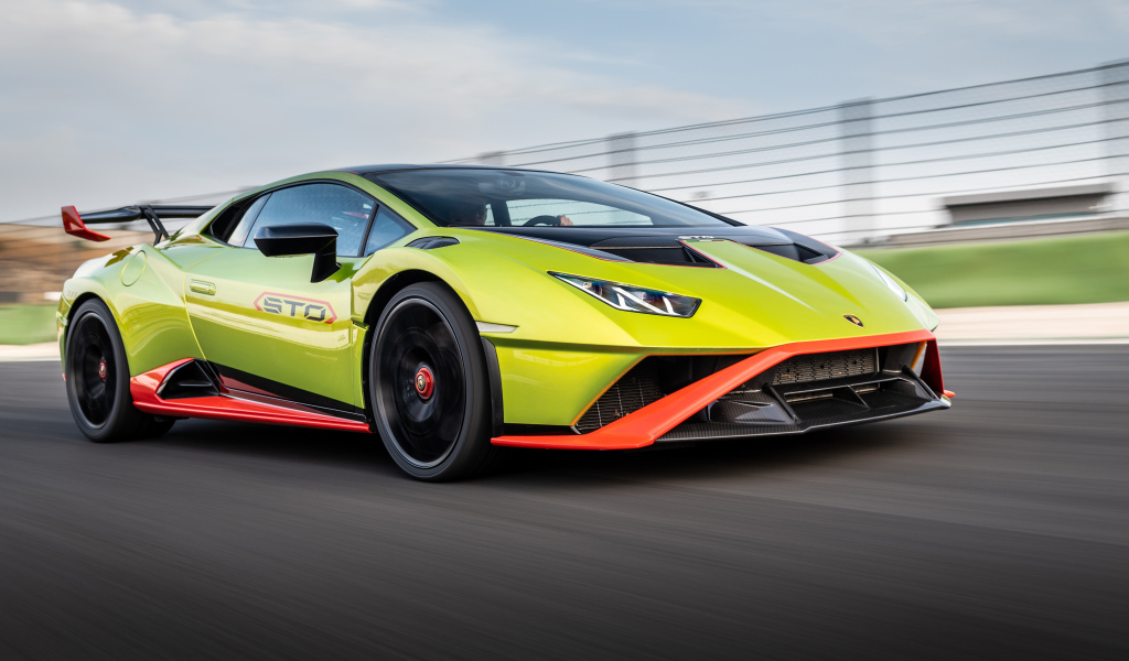 Зеленый автомобиль Lamborghini Huracán STO 2021 года на высокой скорости 