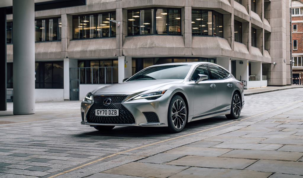 Серебристый автомобиль Lexus LS 500h 2021 года в городе у дома