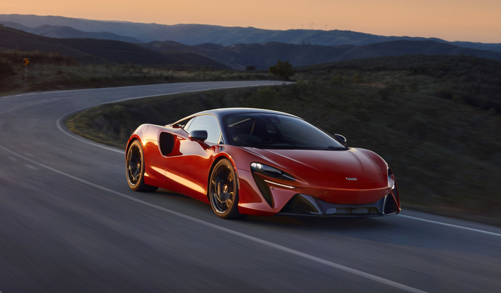 Красный автомобиль McLaren Artura, 2022 года на трассе