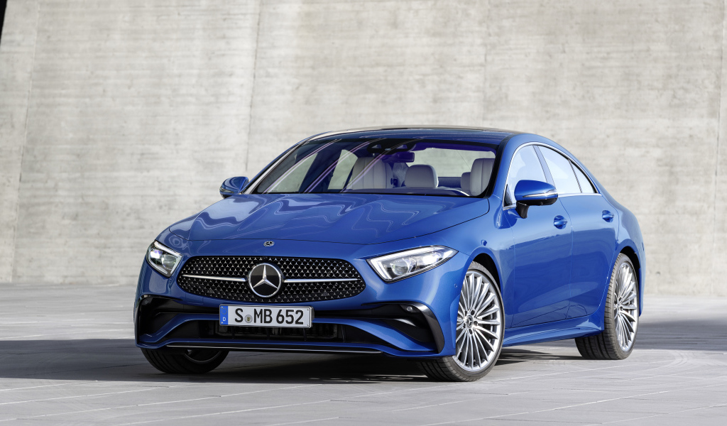 Синий автомобиль Mercedes-Benz CLS 350 AMG Line 2021 года на фоне серой стены