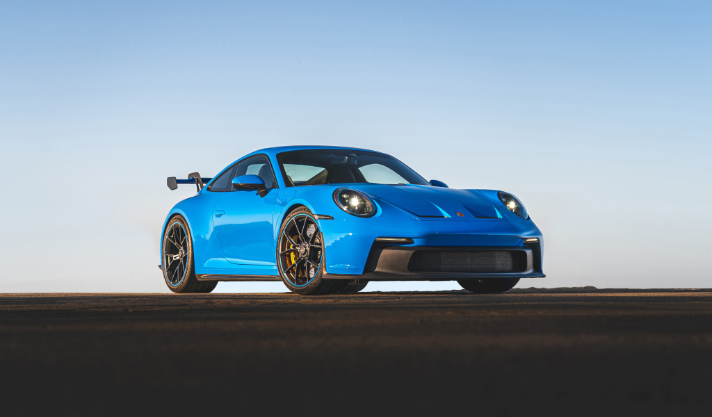 Синий автомобиль Porsche 911 GT3 2021 года на фоне неба