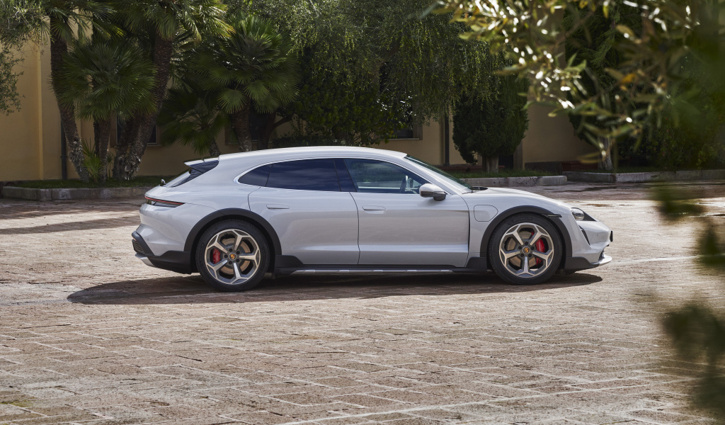 Серебристый автомобиль Porsche Taycan 4S Cross Turismo 2021 года у дома