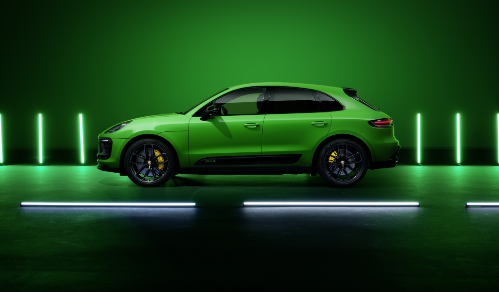Зеленый автомобиль Porsche Macan GTS Sport Package 2021 года на фоне стены 