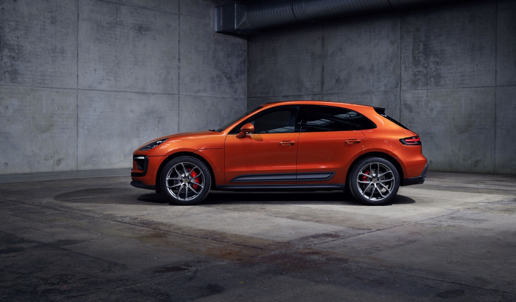Оранжевый Porsche Macan S 2021  года на сером фоне