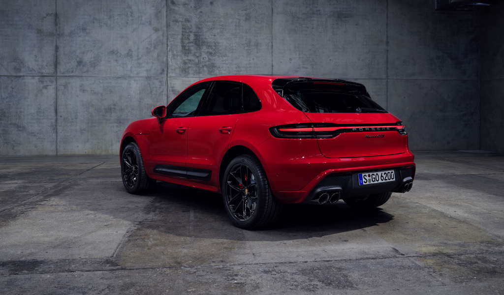 Красный автомобиль Porsche Macan GTS 2021 года на сером фоне вид сзади