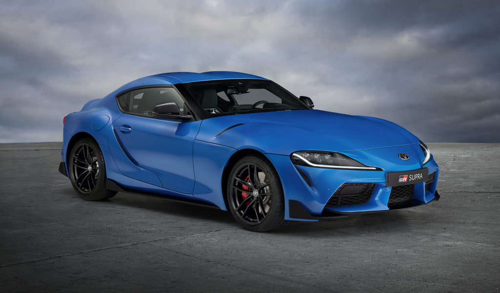 Синий автомобиль Toyota GR Supra, 2021 года на сером фоне