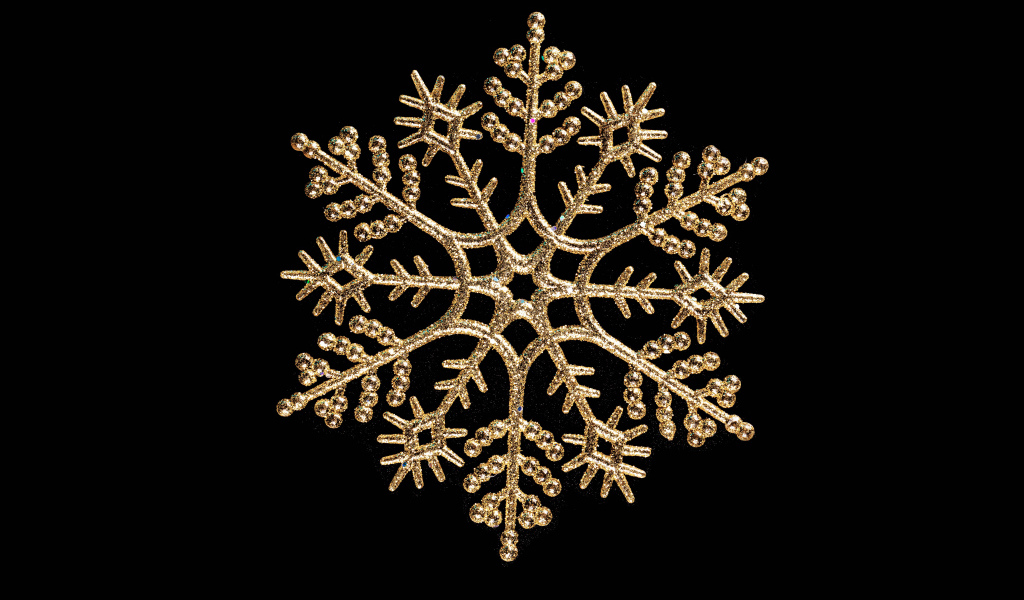 Красивая золотистая снежинка на черном фоне