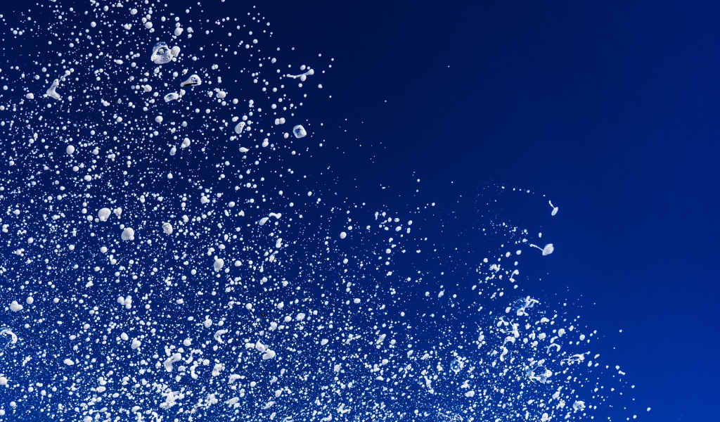 Белые брызги воды на синем фоне 