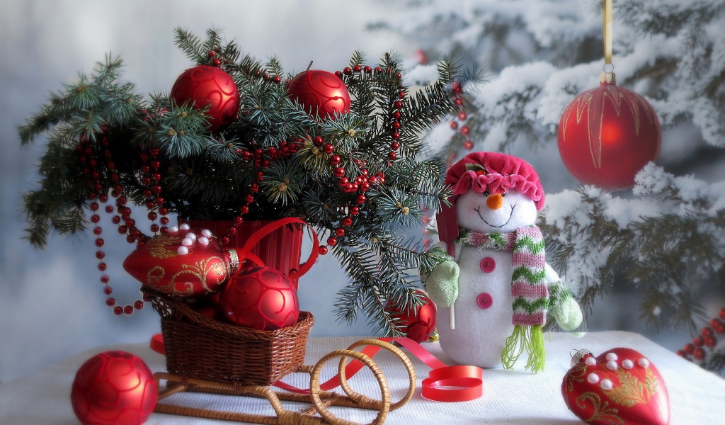 Еловая ветка украшена красным декором к Рождеству 