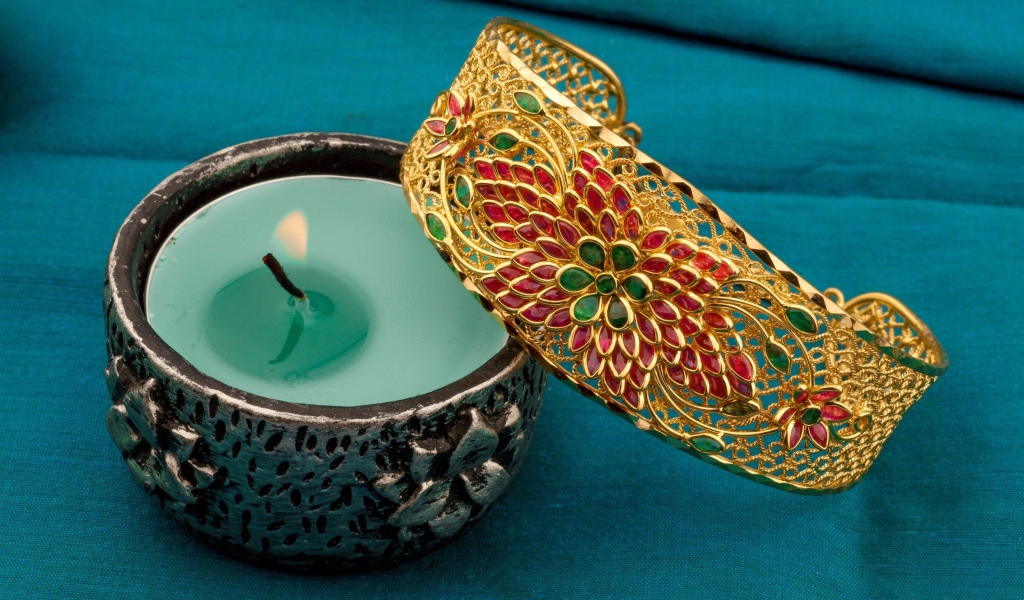 Красивый браслет со свечой на синем покрывале 