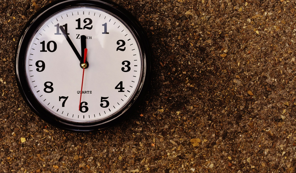 Большие черные часы висят на стене 