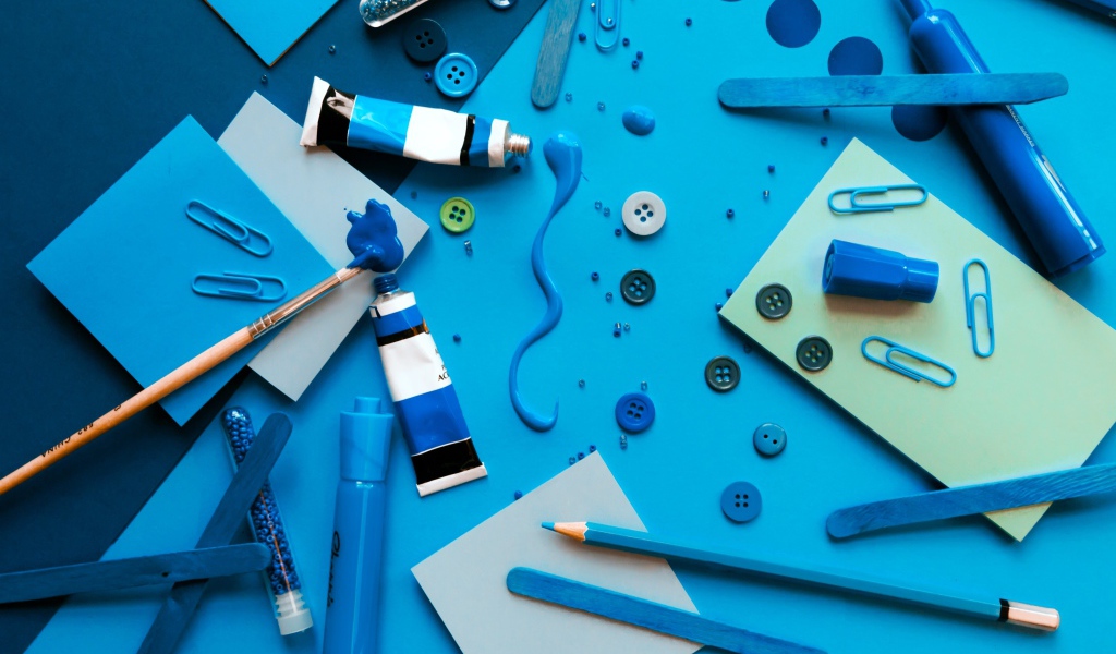 Синие канцелярские предметы, бумага и краски на столе 