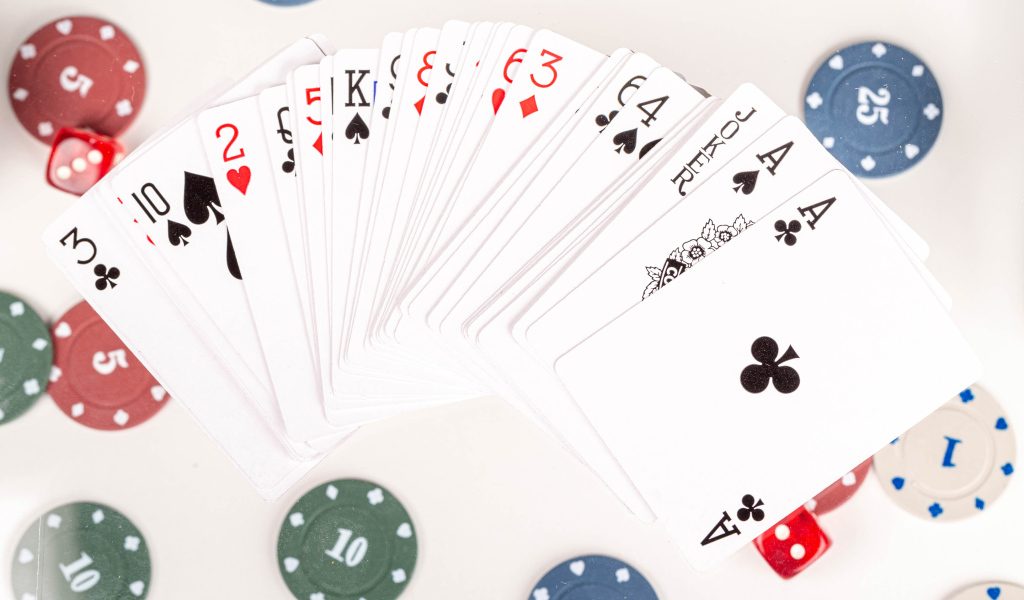 Колода игральных карт и фишки на столе в казино 