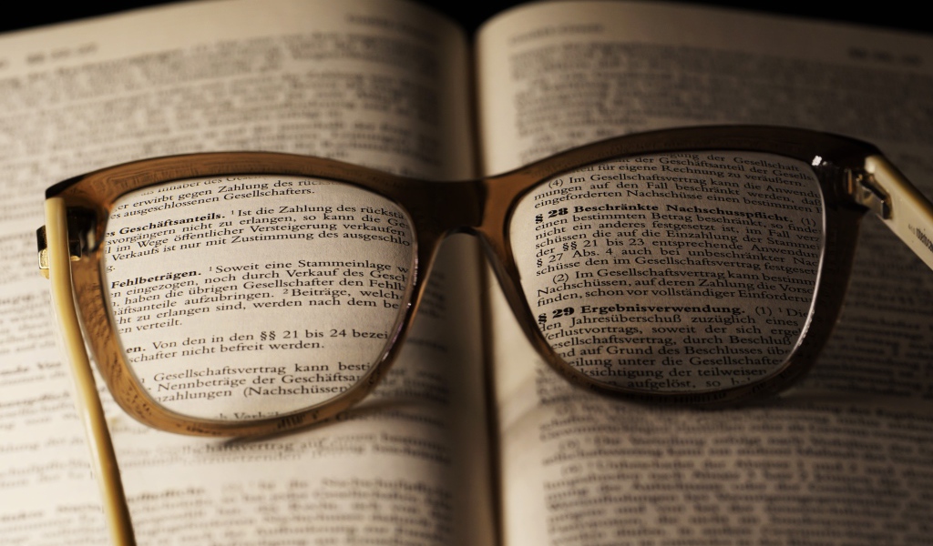 Очки для зрения лежат на открытой книге