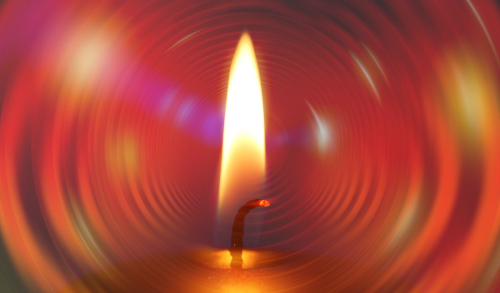 Огонь свечи на фоне красного круга 