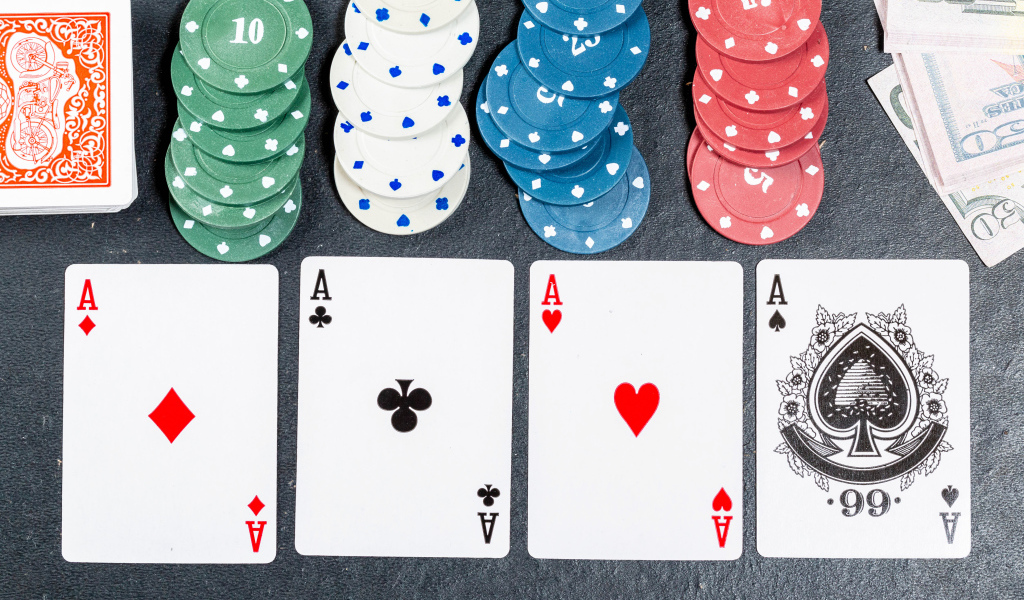 Четыре туза с фишками на сером столе