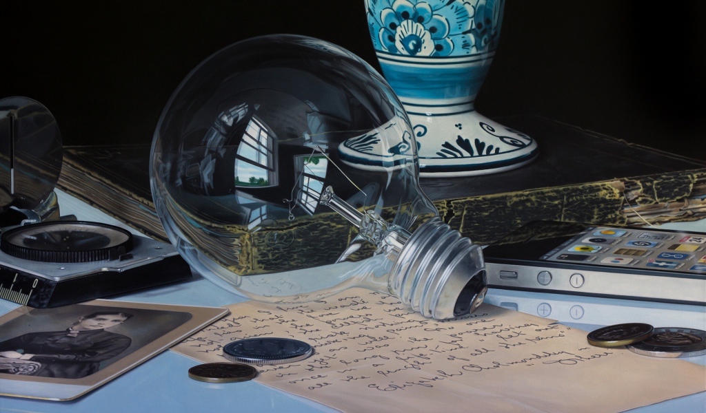 Стеклянная лампочка на столе с монетами и письмом
