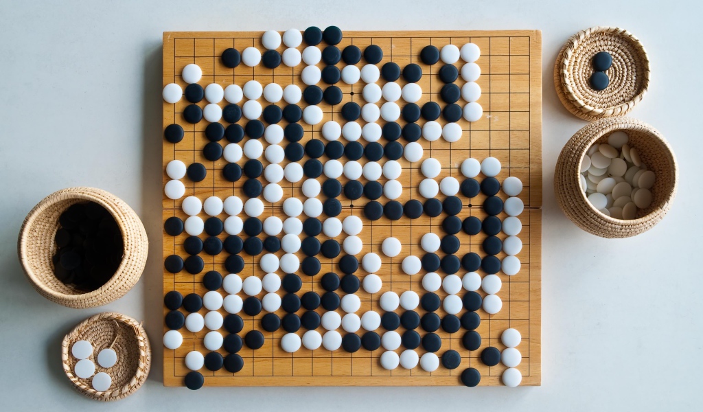 Игра Го на доске на столе
