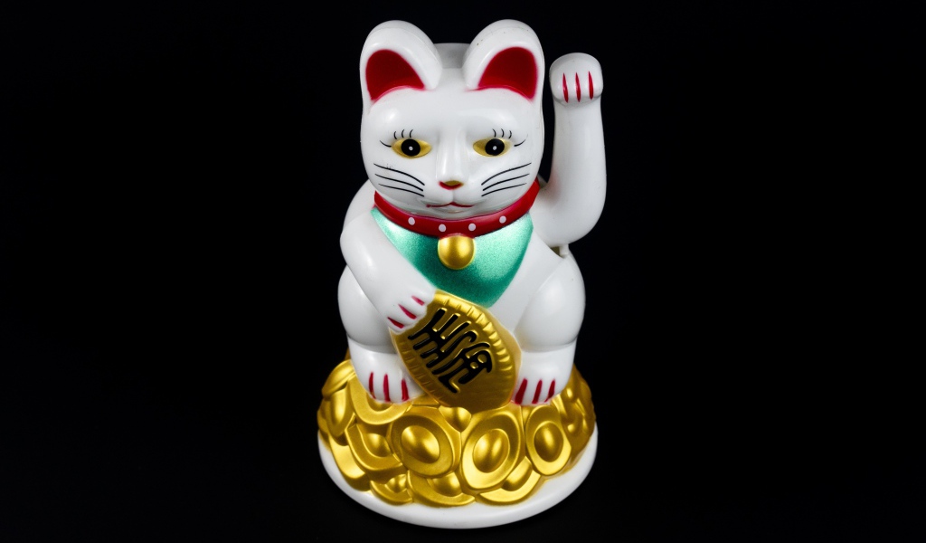 Японская фигурка манэки-нэко кошка на черном фоне
