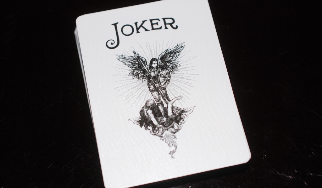 Joker card on black background on the table