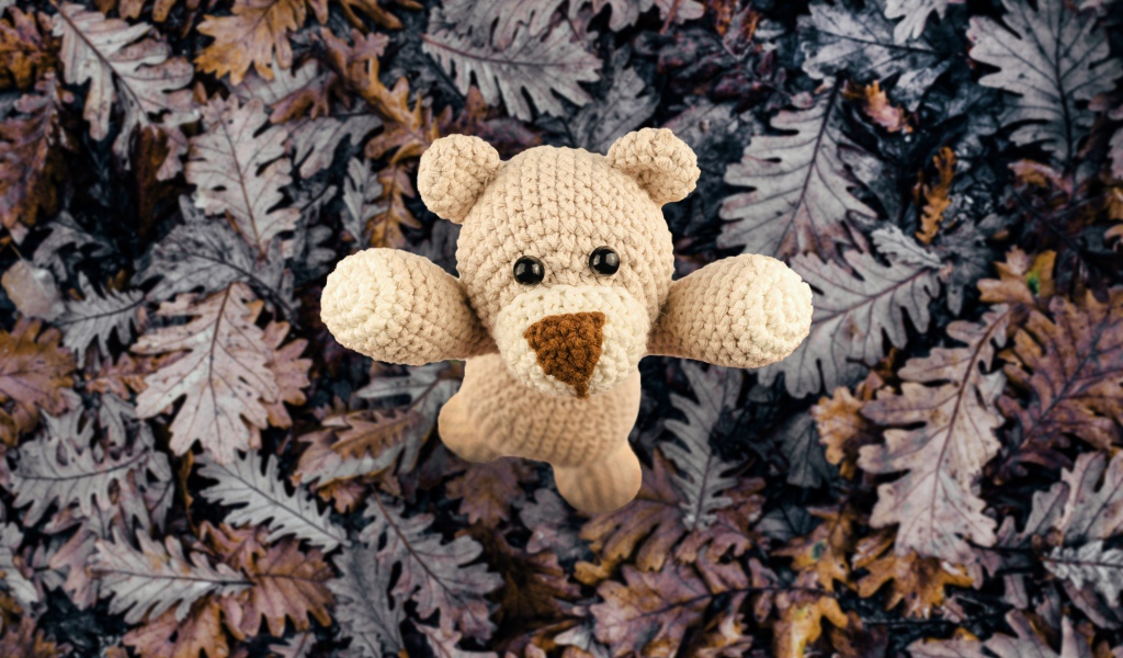 Вязаная игрушка медвежонок на листве