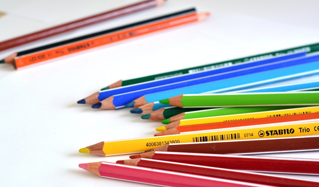 Разноцветные карандаши на белом столе 