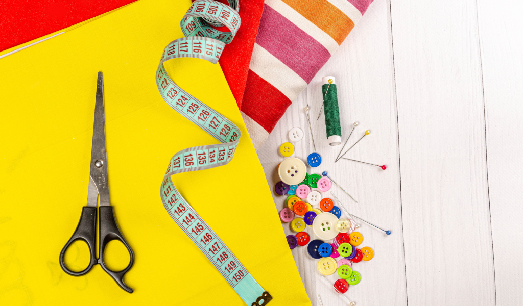 Разноцветная бумага и набор для шитья на столе 