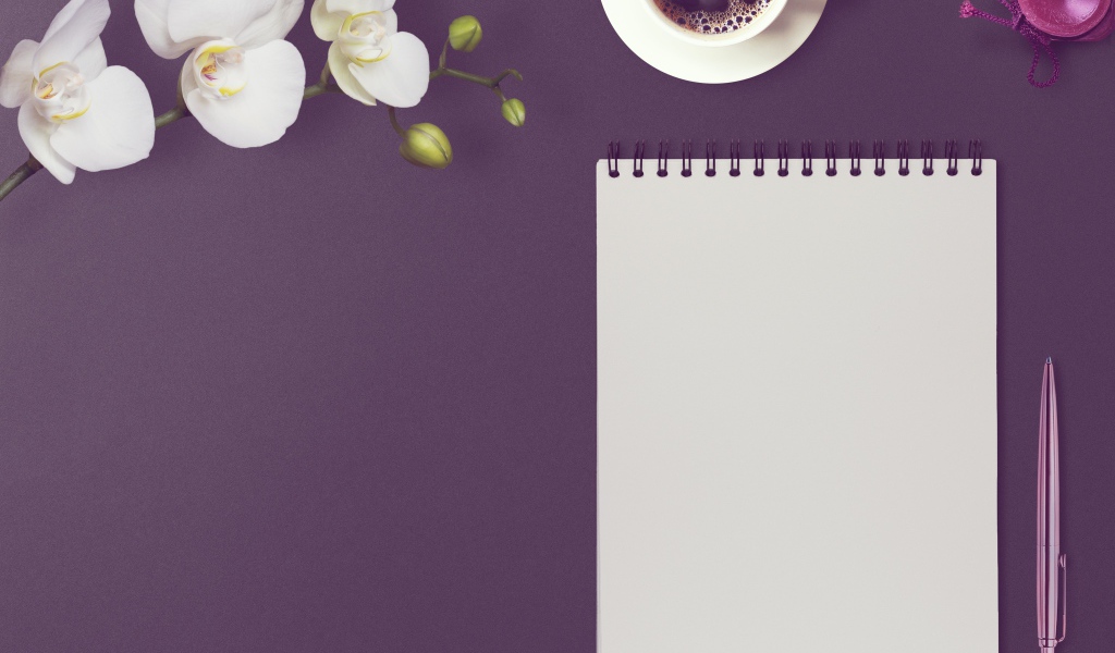 Блокнот с ручкой, цветами орхидеи и кофе на сиреневом фоне