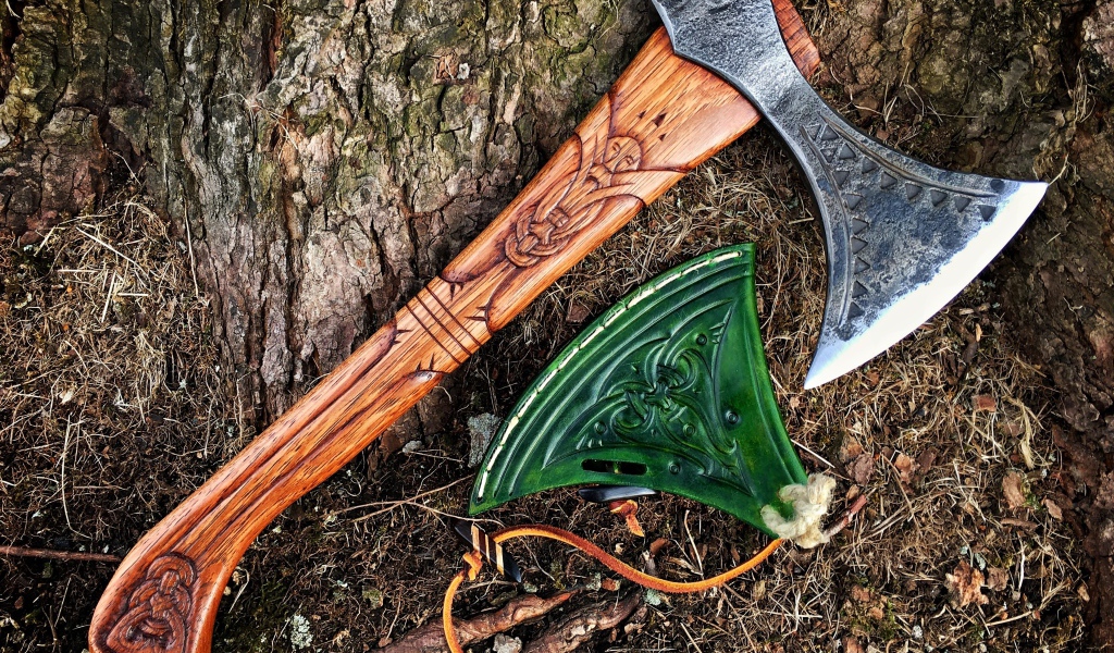 Старый топор с рисунком у дерева 