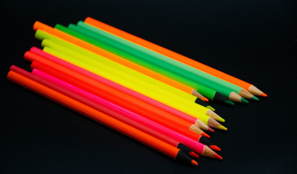 Палитра разноцветных карандашей на черном фоне