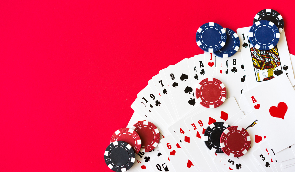 Карты для покера и фишки на красном фоне 