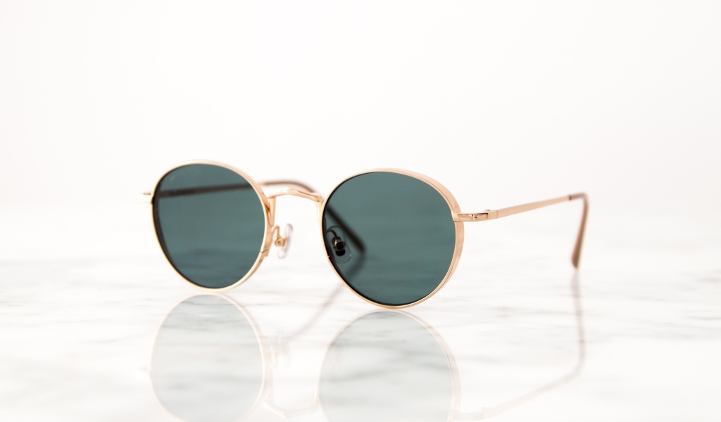 Солнечные очки лежат на зеркальной поверхности