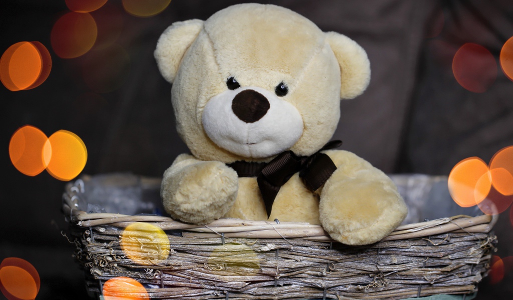 Плюшевый медведь сидит в корзине