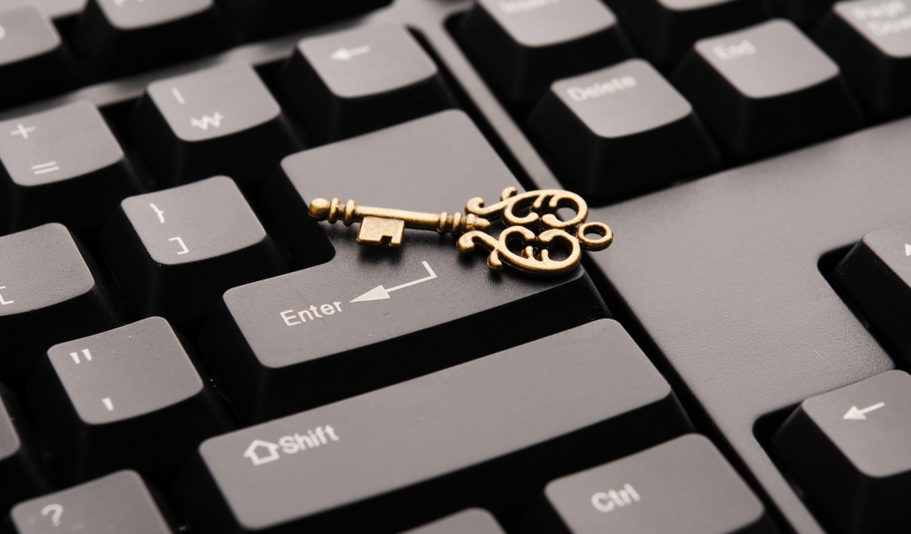 Золотой ключ лежит на черной клавиатуре