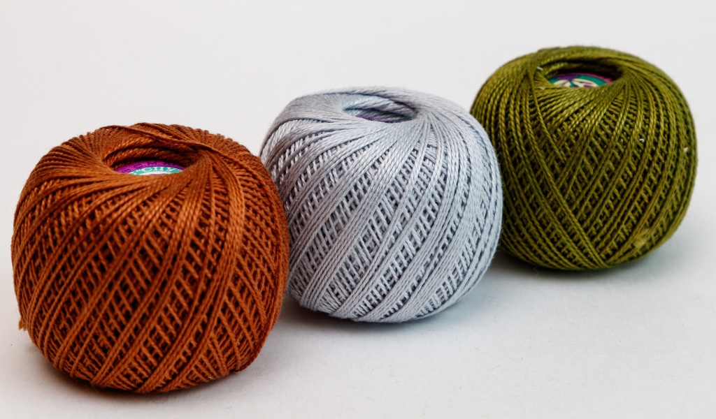 Три клубка пряжи на белом фоне 