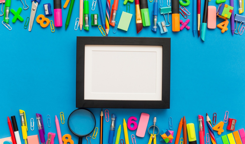 Белая рамка с разноцветными канцелярскими предметами на голубом фоне