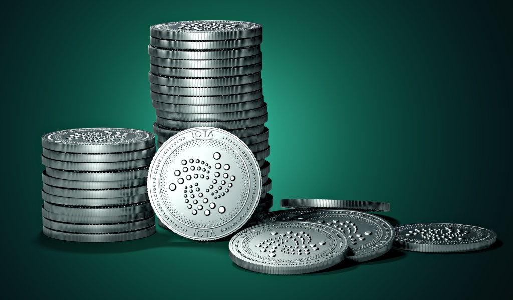 Монеты IOTA на зеленом фоне