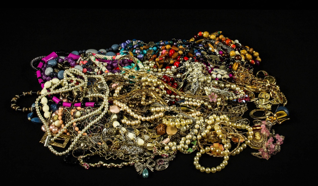 Много драгоценных ювелирных украшений на черном фоне