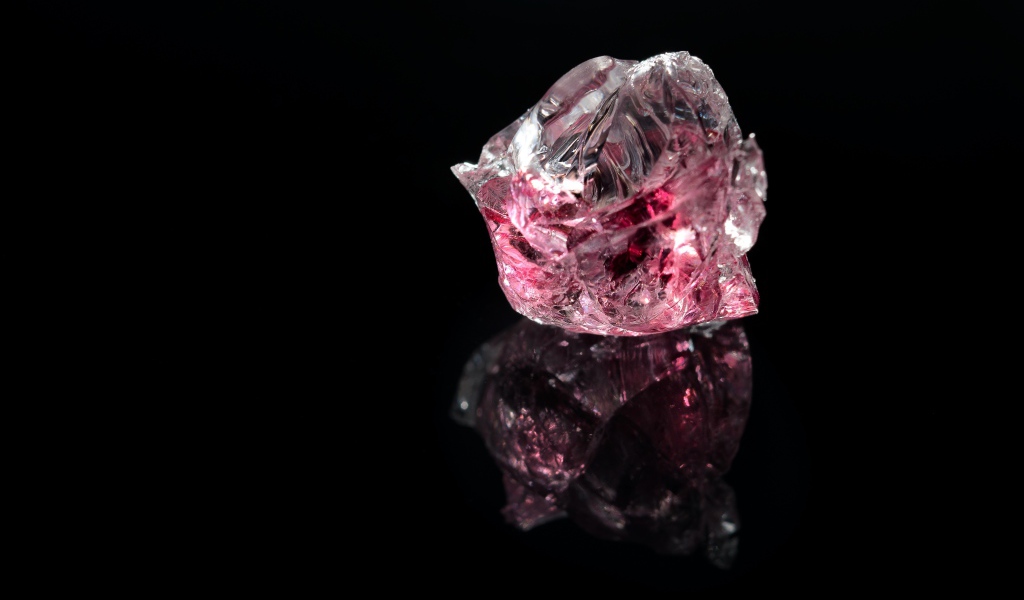 Розовый драгоценный камень на черном фоне 