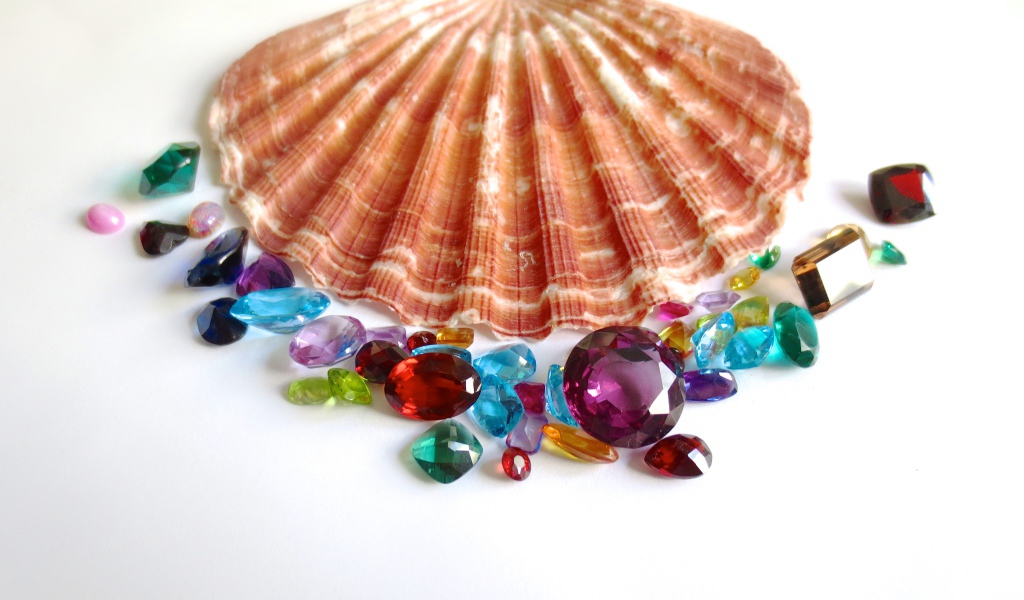 Ракушка и драгоценные камни на белом фоне
