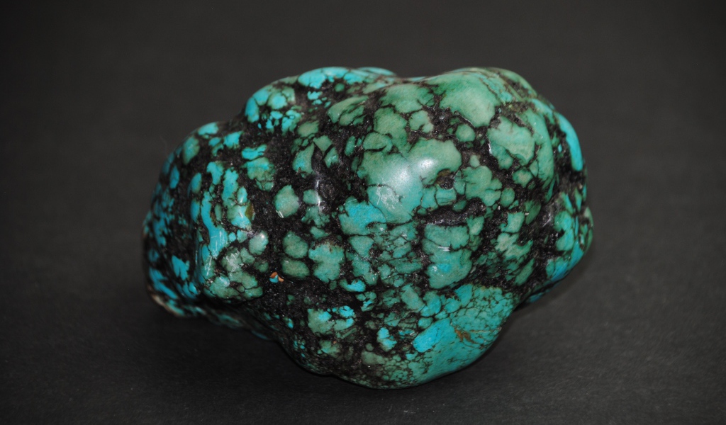 Драгоценный камень бирюзы на сером фоне