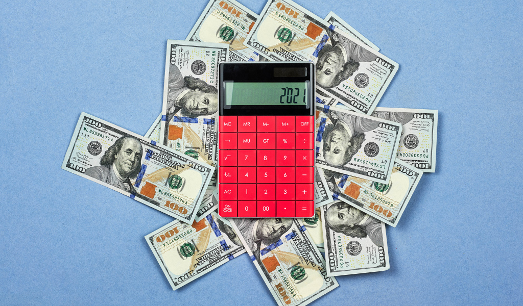 Много долларов с калькулятором на синем фоне