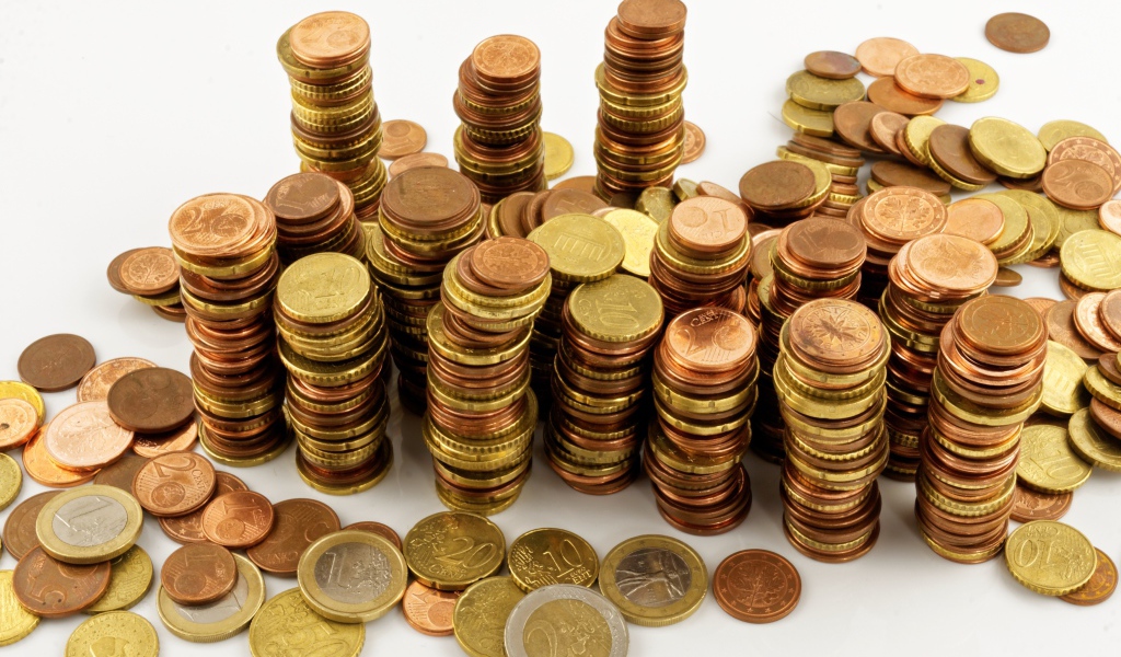 Много блестящих  монет евро на белом фоне