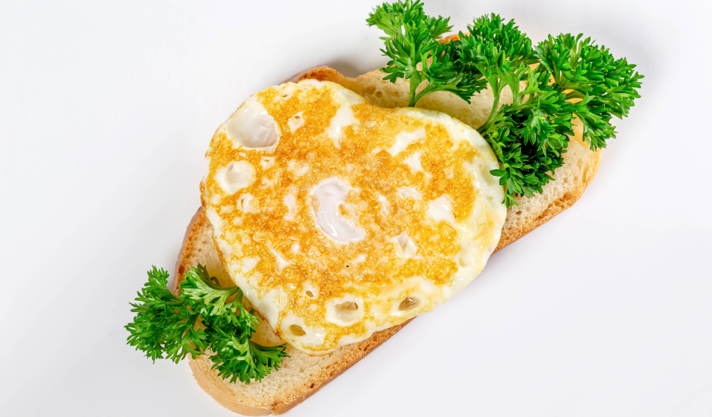 Кусок хлеба с яичницей и петрушкой