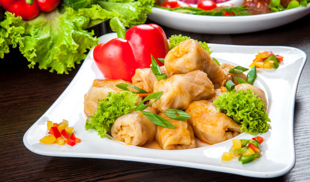 Аппетитные голубцы на тарелке с перцем 