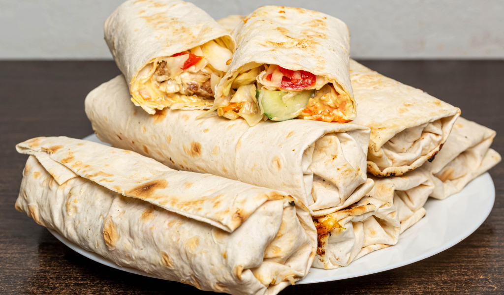 Аппетитная шаурма в лаваше на столе 