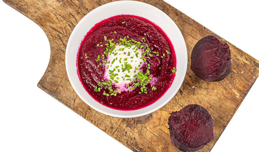 Свекольный суп в тарелке на белом фоне