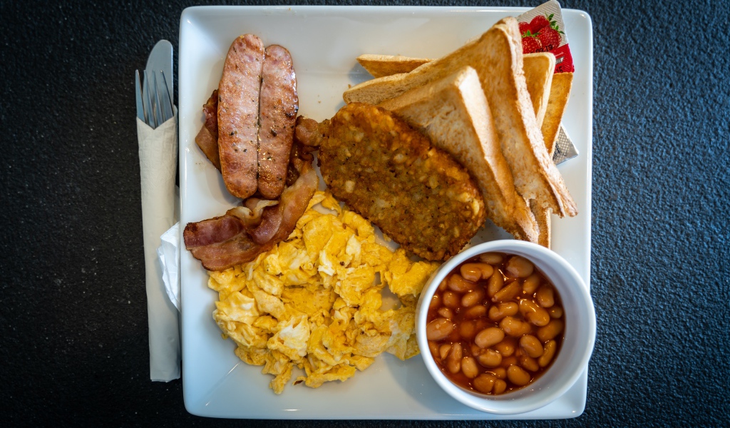 Завтрак на белой тарелке на черном столе 